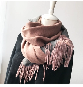 Detailed shot of double-sided pink and grey cashmere scarf with long fringe edges