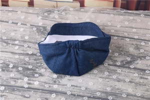 Detail of navy denim beret showing white lining and elastic back band for babies