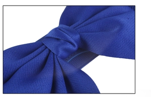 Macro detail of the navy blue twill fabric bow and central knot on the elastic waist belt