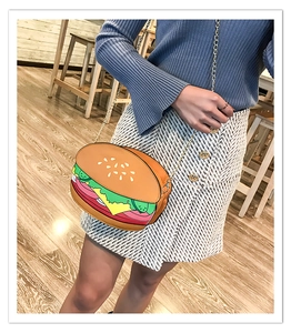 Model wearing a creative hamburger shaped crossbody bag with a metal chain strap