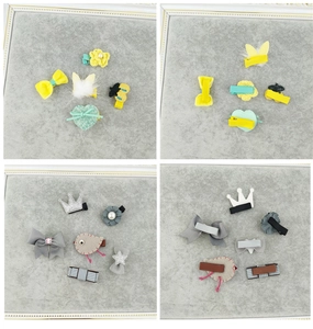 Detail of children's hair clip sets featuring mink fur crowns and bows on velvet trays