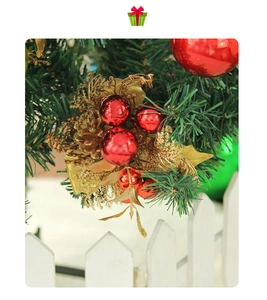 Close-up of red berries and gold pinecones on a Christmas tree with white fence decoration