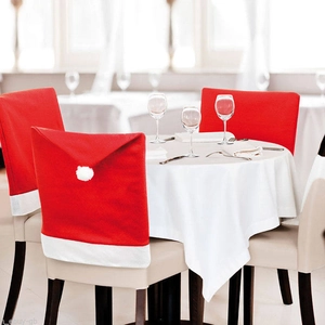 Red Christmas hat chair cover with white trim and pom pom for festive table decor