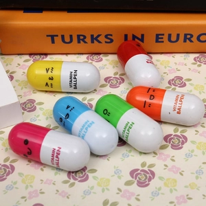 Detailed view of six colorful pill-shaped capsule ballpoint pens with cute emoji faces