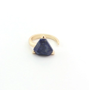 Macro detail of gold open ring featuring a triangle-cut blue lapis lazuli gemstone