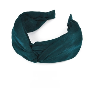 Macro shot of dark green velvet wide-brim headband with a knotted center design