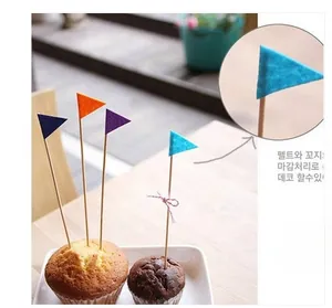 Close-up of colorful felt mini triangle flag cake toppers for anniversary party decor