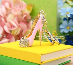 Close-up of pink high heel keychain with white rhinestones on colorful books