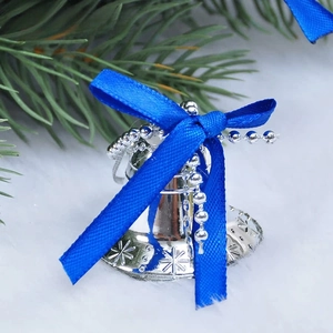 Macro shot of a silver Christmas bell with snowflake relief and a blue satin ribbon bow
