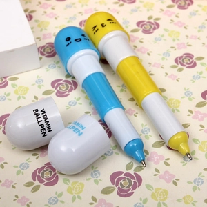Macro shot of colorful pill-shaped ballpoint pens with cute faces and vitamin text