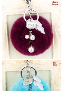 Détail de porte-clés en peluche avec plaques vintage en métal et breloques en perles