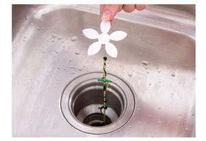 Detail of flower drain chain hair catcher being used in a stainless steel kitchen sink