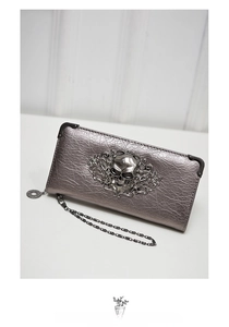 Detail of silver skull ornament and metallic embossed leather on long gothic wallet
