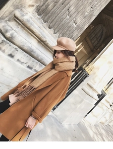 Detailed view of camel wool coat styled with a matching mohair scarf and newsboy cap