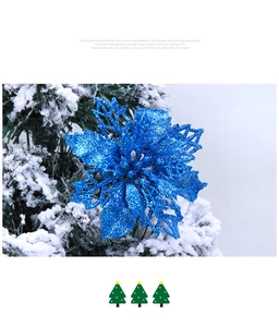Blue glitter artificial poinsettia flower on snow-covered Christmas tree branch detail