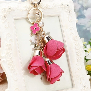 Detail of pink leather flower tassels keychain with golden clover and crystal bead