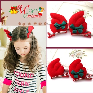 Close-up of Christmas reindeer ear hair clips with green bows and red metal duckbill clips