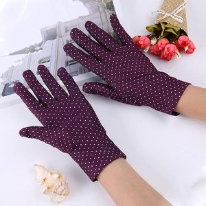 Detailed view of purple polka dot gloves for sun protection on a stylish magazine background