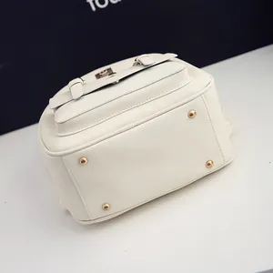 Detail des weißen Saffiano-Lederrucksacks mit goldenem Logo und schützenden Metallfüßen