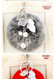 Détail d'un porte-clés en peluche avec perles et ornements de feuilles en rouge et gris