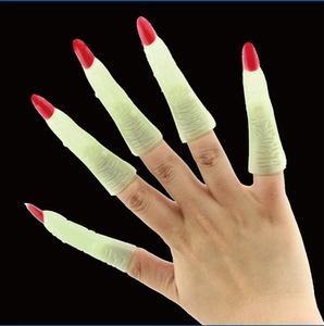 Detailed view of grey Halloween witch fingers with red nails worn on hand against black backdrop