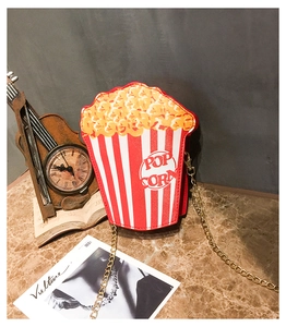 Detail of creative popcorn shaped crossbody bag with red stripes and golden chain