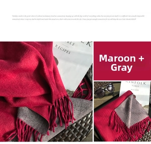 Macro detail of thick burgundy and grey cashmere-like scarf with fringe tassels