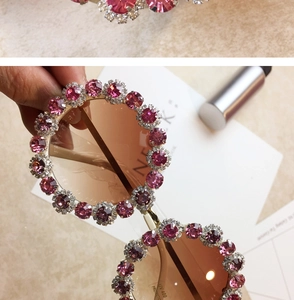 Detailed view of pink crystal rhinestones and tea lenses on oversized round sunglasses