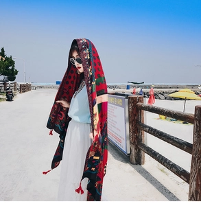 Close-up of Bohemian red floral print shawl with decorative tassels for sun protection