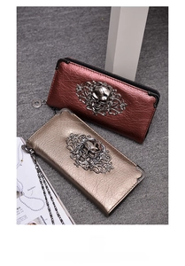 Macro view of vintage punk skull clutch wallet with metal corners and cracked leather detail