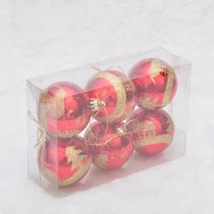 Detail of red Christmas ornaments with gold glitter tree patterns in a transparent box