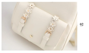 Detailansicht eines cremeweißen Rucksacks mit 3D-Blumenapplikationen und Goldbeschlägen