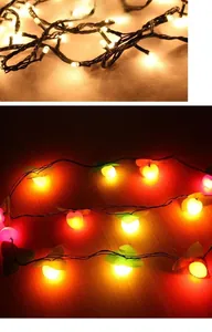 Detail of warm white micro LED string lights and festive red apple shaped holiday bulbs