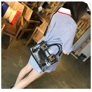 Detailed view of clear PVC jelly bag with black inner pouch on a female shoulder