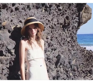 Close-up of a French vintage straw cloche hat with black ribbon in a seaside setting