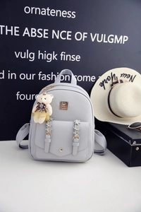 Detailansicht graublauer PU-Lederrucksack mit Bärenanhänger und floralen Trägern