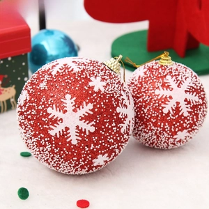 Close-up of red Christmas ball with white snowflakes and textured foam particles