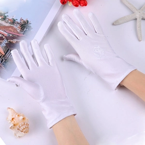 Detailed close-up of white satin sun gloves featuring delicate floral embroidery motifs