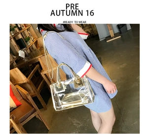 Detailed shot of a transparent PVC jelly bag with gold trim and chain strap on a model