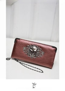 Detail of metallic purple punk skull wallet featuring silver skull emblem and metal chain