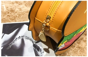 Detail view of the golden metal zipper and layered leather texture of the burger-shaped bag