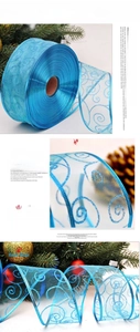 Detail of royal blue sheer Christmas ribbon with glitter scroll patterns for holiday decor