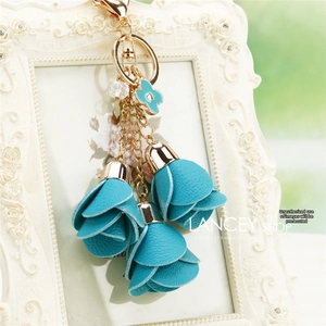 Detailed close-up of blue bellflower charms with golden clasp and clover pendant