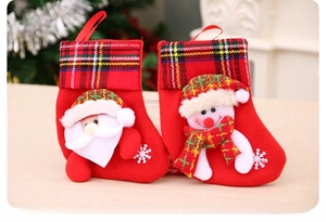 Detail of red Christmas stockings featuring 3D Santa and snowman with plaid cuffs