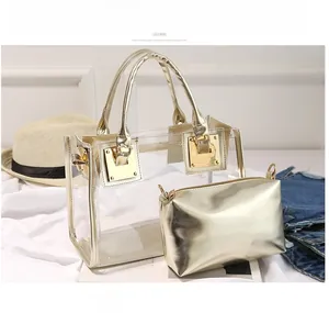 Detailed view of clear PVC tote with gold PU trim and matching inner pouch on white fabric