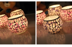 Detail of a round mosaic glass candle holder with soft pink and purple tones in a warm setting