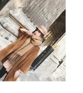 Detail of soft mohair scarf texture with tassels paired with a wool coat and baker boy hat
