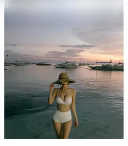 Two-piece white bikini set with halter top and high-waisted bottoms on beach