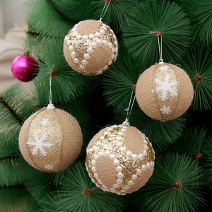 Close-up of linen Christmas balls with pearls and snowflakes on a green pine tree