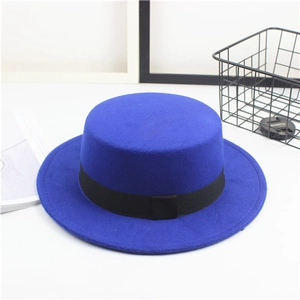 Close-up of royal blue flat top felt hat featuring a decorative black ribbon band